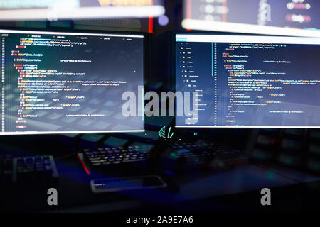 Image of two computer monitors installing the new software in dark office Stock Photo