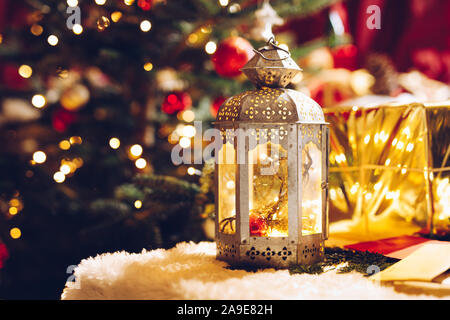 Traditional European Christmas candle in front of wrapped presents. Vintage picture of holiday season in European cottage style. Stock Photo