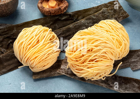 Udon noodles, close-up with dried sea vegetable kelp and shiitake mushrooms, ramen ingredients Stock Photo