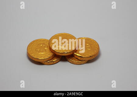 chocolate shaped like coins in gold foil sheet isolated on white background Stock Photo