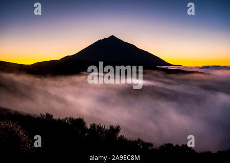 Beautiful el teide tenerife vulcan landscape with  high top and clouds in the ground like mist fog - timeless and national park scenic outdoor place - Stock Photo