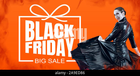 Woman as a vampire in black dress on orange fire background, black friday. Scary characters, business, advertising. Black friday, cyber monday, sales, finance, money online purchases concept. Stock Photo