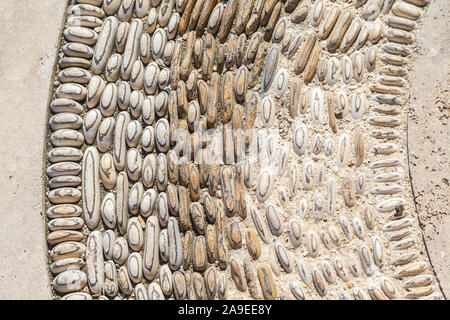A round mosaic sample from stones or pebbles, medium close-up, structure, background, Stock Photo