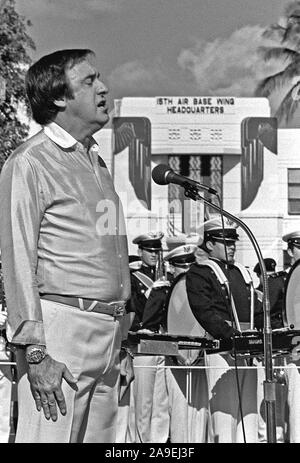 Jim Nabors sings the national anthem at the beginning of a ceremony marking the transfer of the U.S. flag flown over Hickam during the 1941 Japanese attack from the Air Force Academy Museum back to the base. Stock Photo