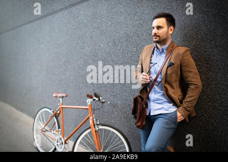 Businessman with bicycle to work on urban street in city. Transport and healthy lifestyle concept Stock Photo