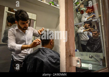 A barber cutting hair near the Grand Bazaar, Istanbul, Turkey Stock Photo