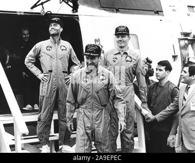 The crew of the Apollo 13 mission step aboard the U.S.S. Iwo Jima, prime recovery ship for the mission, following splashdown and recovery operations in the South Pacific. Exiting the helicopter (from left) astronauts Fred. W. Haise, Jr., lunar module pilot; James A. Lovell Jr., commander; and John L. Swigert Jr., command module pilot. The Apollo 13 spacecraft splashed down at 12:07:44 pm CST on April 17, 1970. Stock Photo