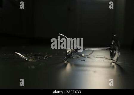 Broken wine glass lying on the floor Stock Photo