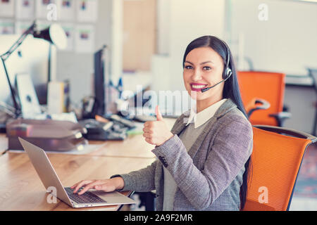 Beautiful call center agent browsing the internet on her computer Stock Photo