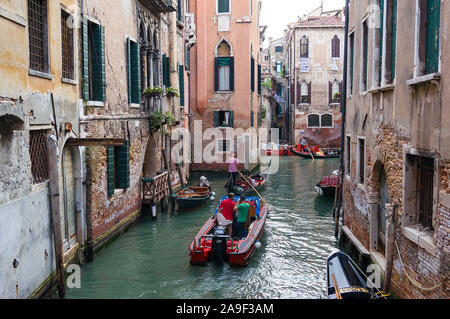 Venice, Italy - September 27, 2013: Venice water infrastructure. People in gondola, motor boat traveling Venice streets Stock Photo