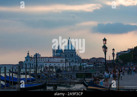 Venice, Italy - September 27, 2013: Gondola station with view of Basilica di Santa Maria della Salute at dusk. Venetian landmarks Stock Photo