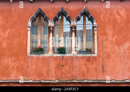 Beautiful Gothic lancet windows on red terracotta wall Stock Photo