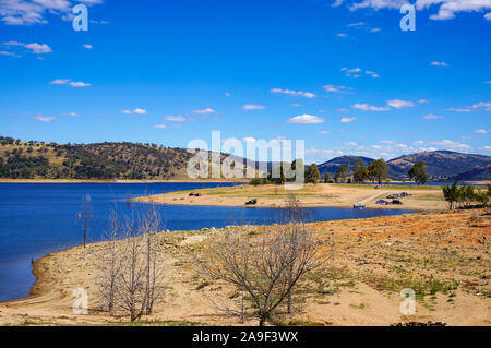 Australian outback landscape of lake, dam and dry trees with fishermen in the distance. Wyangala Dam Stock Photo