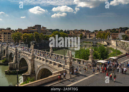 Beautiful view from Castel Sant'Angelo on the bridge, people walking on it and Tiber river. Beautiful sunny weather in Rome, fairytale look like. Stock Photo