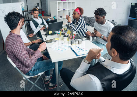 A group of promising businessmen are discussing the growth of profits on the example of graphs Stock Photo