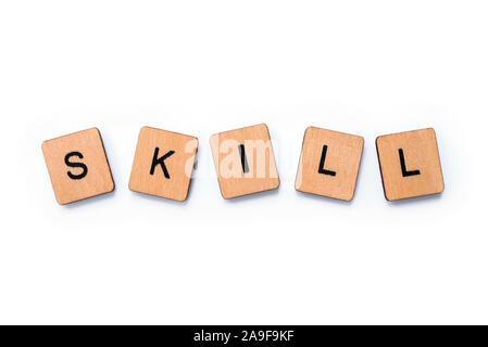 The word SKILL, spelt with wooden letter tiles over a white background. Stock Photo