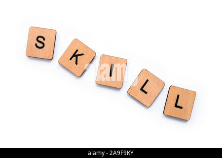 The word SKILL, spelt with wooden letter tiles over a white background. Stock Photo