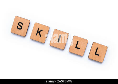 The word SKILL, spelt with wooden letter tiles over a white background. Stock Photo