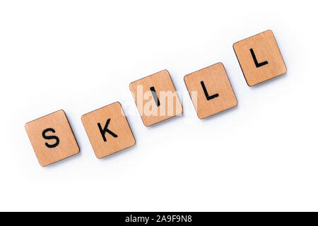 The word SKILL, spelt with wooden letter tiles over a white background. Stock Photo