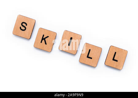 The word SKILL, spelt with wooden letter tiles over a white background. Stock Photo