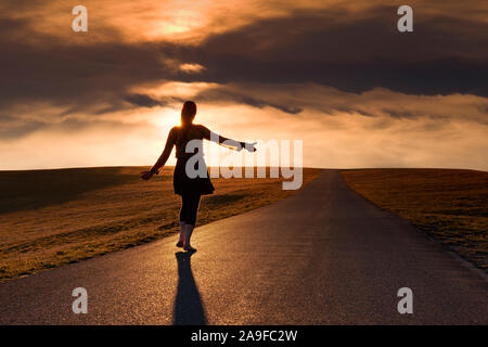 Silhouette of a woman hitchhiking Stock Photo