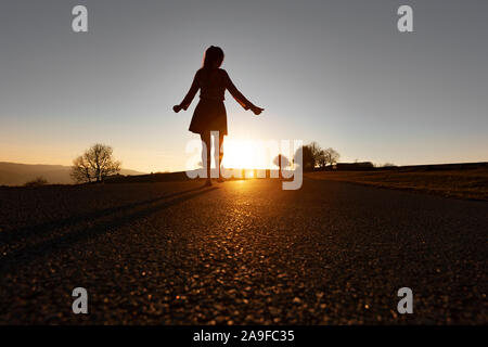 Silhouette of a woman hitchhiking Stock Photo