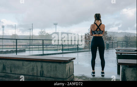 Sportswoman posing backwards watching the rain Stock Photo