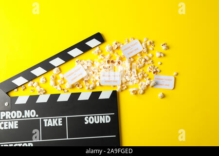 Flat lay composition with clapperboard, popcorn and tickets on yellow background Stock Photo