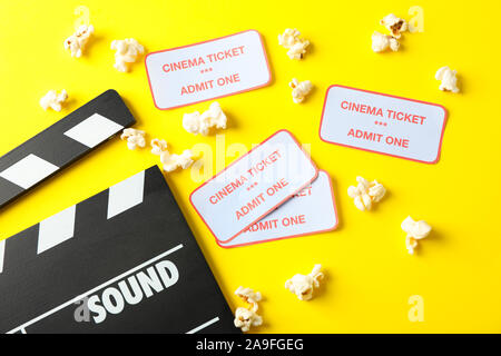Flat lay composition with clapperboard, popcorn and tickets on yellow background Stock Photo