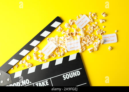 Flat lay composition with clapperboard, popcorn and tickets on yellow background Stock Photo