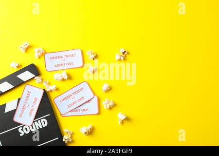 Flat lay composition with clapperboard, popcorn and tickets on yellow background Stock Photo