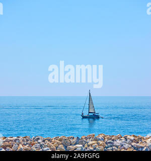 Yacht in the sea near coast on the summer day - Minimalistic seascape Stock Photo