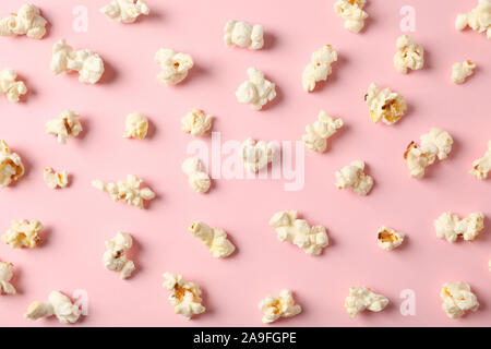 Flat lay composition with popcorn on pink background, closeup Stock Photo