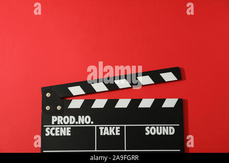 Black clapperboard on red background, space for text Stock Photo