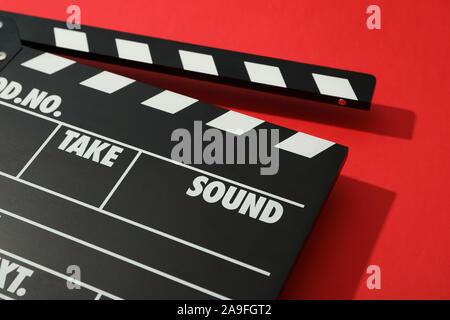 Black clapperboard on red background, space for text Stock Photo