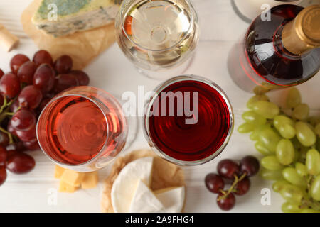 Grape, cheese, bottle and glasses with wine on white background, top view Stock Photo