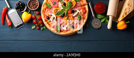 Delicious pizza and ingredients on wooden background, copy space Stock Photo