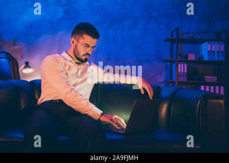 Photo of pensive thoughtful confident serious man browsing through his laptop bearded looking for new information about increasing corporate income Stock Photo