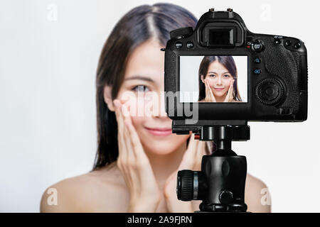 Asian American beauty vlogger creating content for social media vlog, behind camera shot Stock Photo