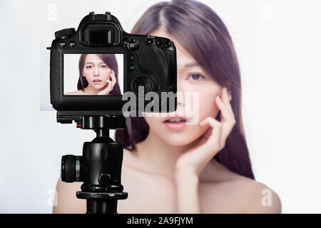 Asian American beauty vlogger creating content for social media vlog, behind camera shot Stock Photo