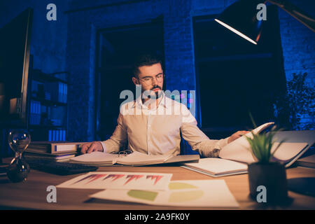 Photo of pensive interested businessman working at consulting company studying reports of his clients company looking for weaknesses in financial Stock Photo