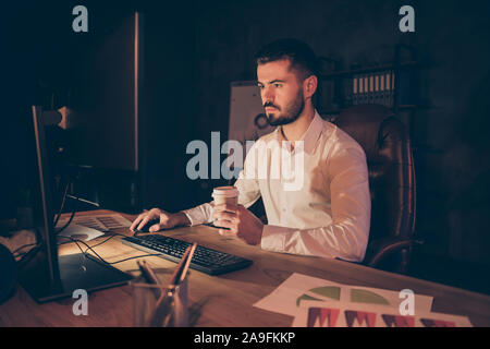Photo of pensive thoughtful entrepreneur looking pensively into screen in search of new information about increasing income of corporation Stock Photo