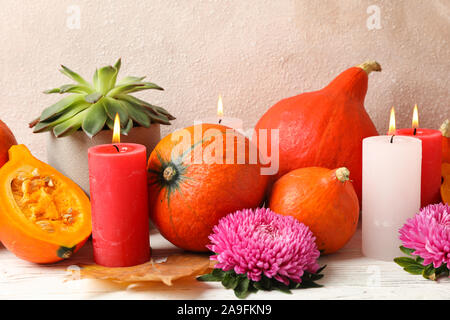 Composition with pumpkins, flowers and candles on white wooden  background, copy space Stock Photo