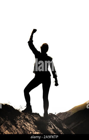 Female silhouette in Victor pose on a rock in front of white background Stock Photo