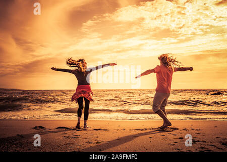 Happy couple on the beach at sunset Stock Photo