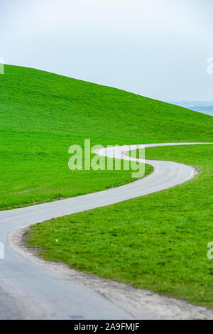Winding country road through meadows Stock Photo
