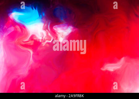 Red and blue inks that mix in the liquid Stock Photo