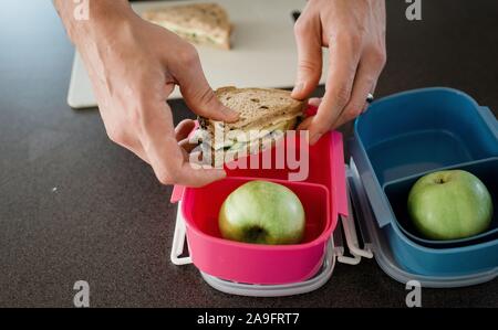 father making a packed lunch box for his kids before school Stock Photo