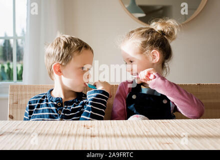 brother and sister brushing their teeth at home before school Stock Photo