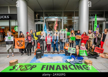 London, UK. 15th Nov 2019. Extinction Rebellion UK gather in front of the investment firm BlackRock to engage in a nonviolent protest to challenge the firm as 'a main player' driving the climate crisis and deforestation around the world. Activists dump a pile of wood ashes  in front of BlackRock’s entrance doors. The group are calling for a year long BoycottForAmazonia, asking people to stop buying products linked to Amazon deforestation and human rights abuses. Credit: Guy Bell/Alamy Live News Stock Photo